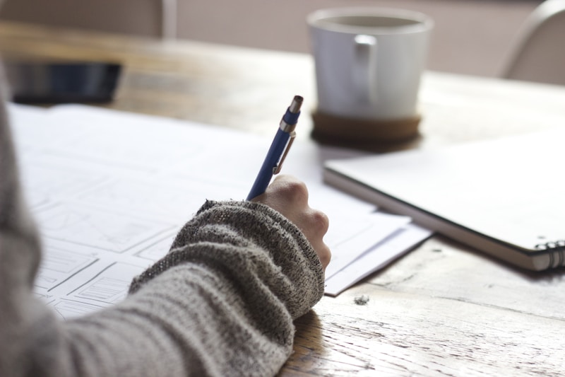 Person studying for AHIP certification with notebook and laptop
