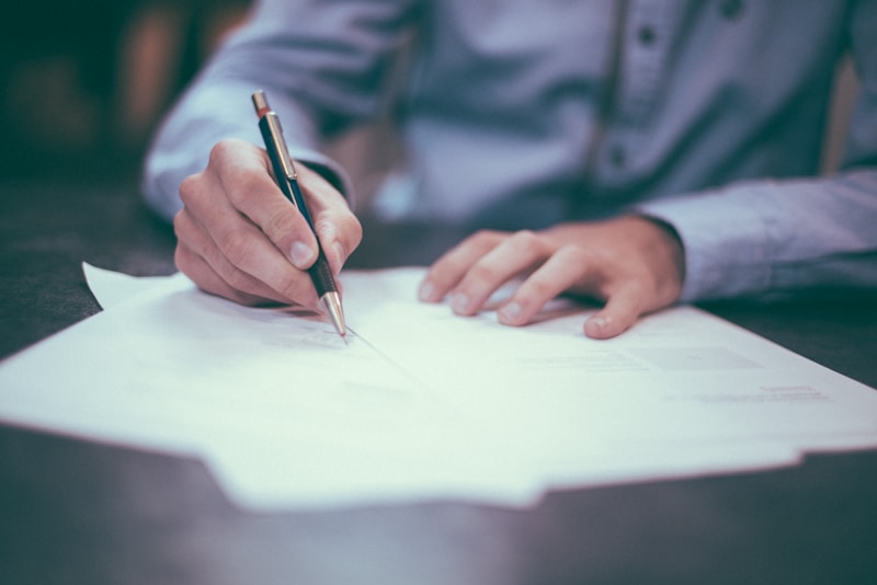 Person reviewing contract documents before signing with an insurance agency