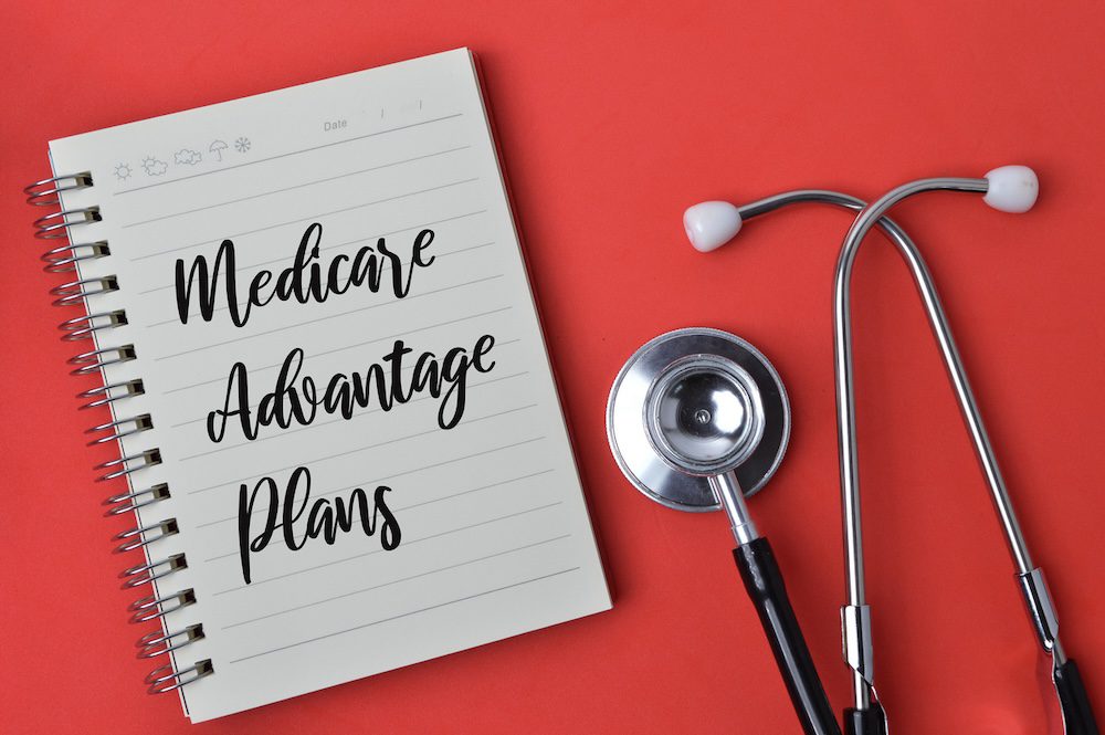 Senior reviewing Medicare Advantage plan benefits with insurance advisor